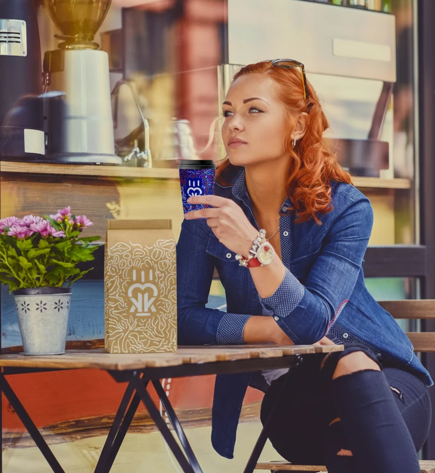 Hölgy kávézik asztalnál tasak az asztalon